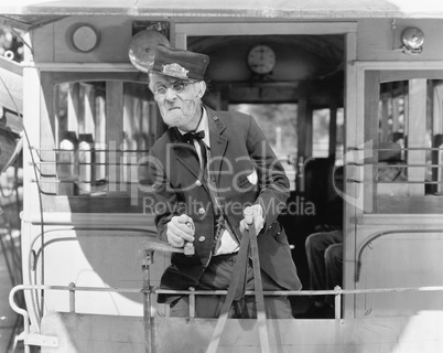 Conductor on a horse drawn streetcar holding the reins