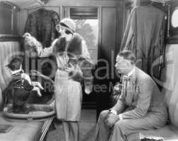 Couple together in a train and feeding a dog