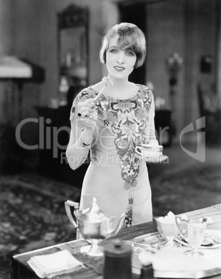 Woman with a cup of tea and a canap in her hands