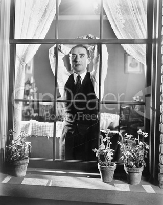 Man leaning against a window while day dreaming