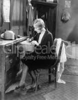 Woman sitting at her desk writing a letter