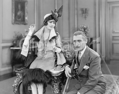 Man with a crutch and a woman sitting together in a living room