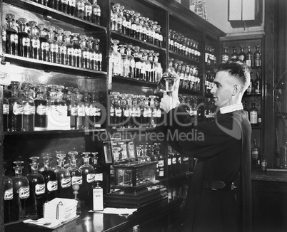 Man in a pharmacy mixing medicine