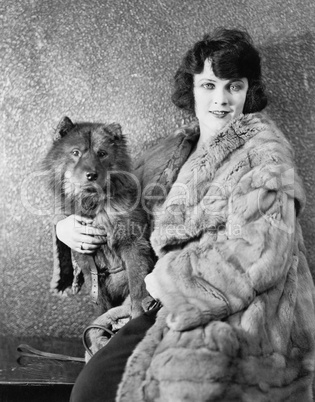 Woman in her fur coat sitting with her dog