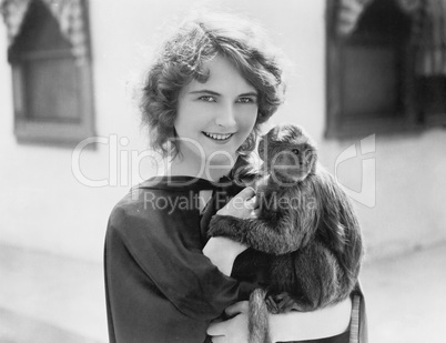 Woman holding a pet monkey in her arms