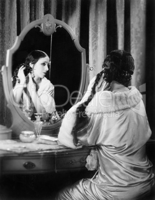 Woman fixing her long hair at her vanity table