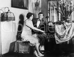 Man sitting with woman playing the piano