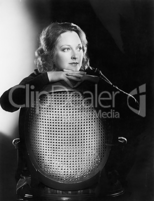 Woman leaning over the back of a chair