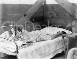 Woman stretched out on a cot reading a book