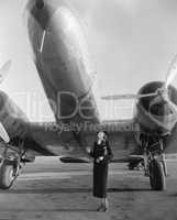 Woman standing under a large aircraft looking up