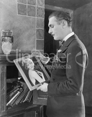 Man studying a picture of a woman