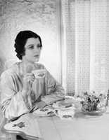 Woman sitting at a table with a tea cup in her hand
