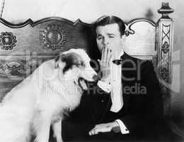 Man and dog sitting together yawning