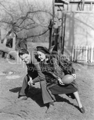 Couple playing football with each other