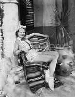 Young woman in a sun suit sitting on a chair