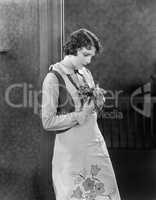 Young woman in an apron holding herbs