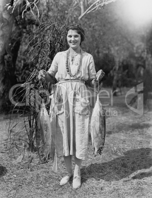 Young woman holding two huge fish
