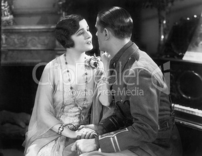 Man in an uniform flirting with a woman in her living room