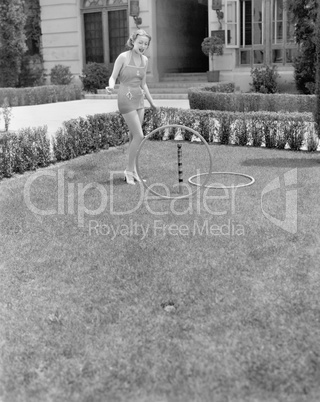 Young woman in a sun suit playing with rings in the yard