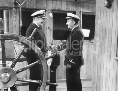 Two captains shaking hands on a boat