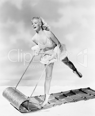 Young woman in an ice-skating outfit on sled