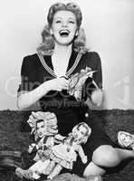 Young woman sitting and cutting out paper dolls