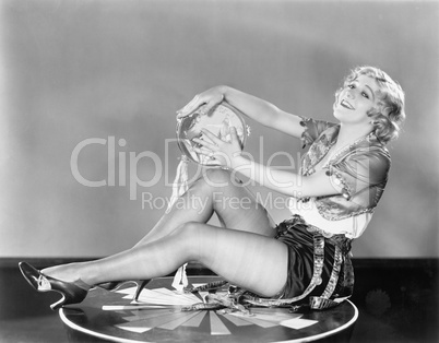 Young woman sitting on a circle playing a tambourine