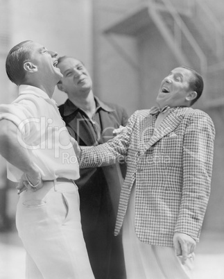 Three men standing together and laughing