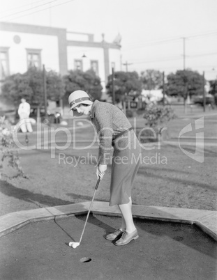 Young woman playing mini golf