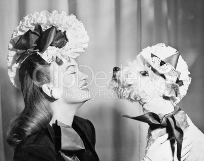 Young woman with her dog who is wearing the same hat