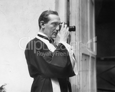 Man holding and looking through a camera