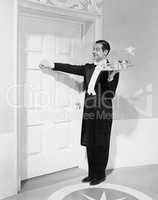Waiter with tray knocking on a door