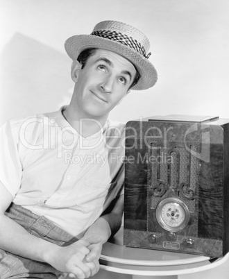 Man in straw hat listening to the radio