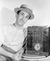 Man in straw hat listening to the radio