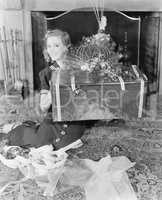 Young woman sitting in a living room showing a present