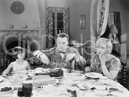 Family of three sitting together having dinner