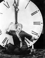 A young woman stretching in front of a giant clock striking midnight