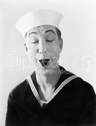 Man in sailor hat and uniform making a silly pantomime face