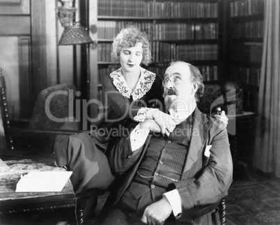 Man sitting on a chair with woman holding his hand