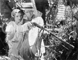 Couple behind their house with a rifle in hand