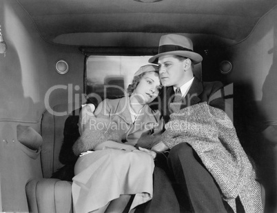 Couple sitting together on the back seat of a car