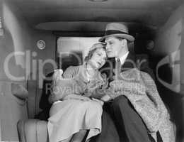 Couple sitting together on the back seat of a car