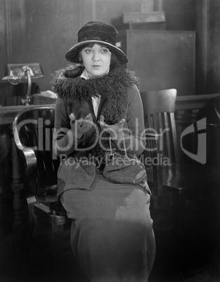 Young woman sitting on a chair in an office trying to explain