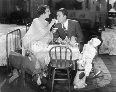 Couple sitting on a toy table having tea together