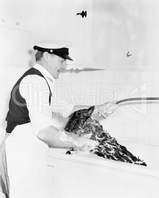 Man washing his dog in a tub