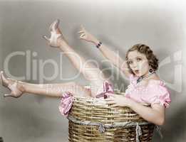 Young woman sitting in a basket looking surprised