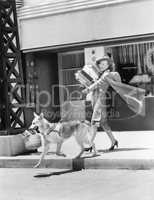 Young woman going shopping with her German shepherd and carrying presents