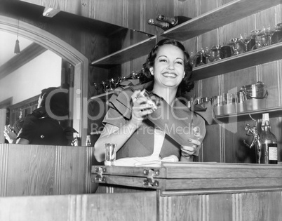 Young woman with a shaker in a bar