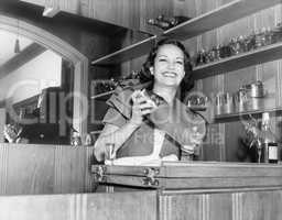 Young woman with a shaker in a bar