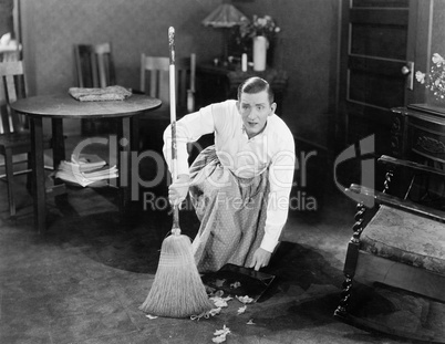 Man cleaning up with a broom